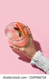 Woman holding glass of tasty grapefruit margarita on color background, closeup - Shutterstock ID 2109586724