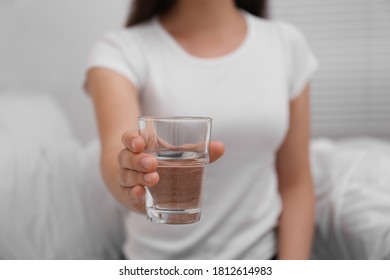Woman holding glass of water in bedroom, closeup - Shutterstock ID 1812614983
