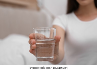 Woman holding glass of water in bedroom, closeup - Shutterstock ID 1826107364