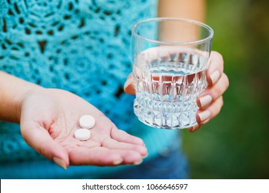 Woman Holding Glass Of Water And Pain Killer Pill