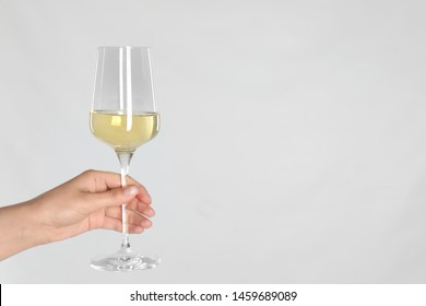 Woman Holding Glass Of White Wine On Light Background, Closeup. Space For Text