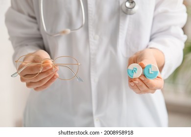 Woman Holding Glasses And Contact Lens Case In Clinic