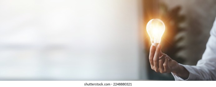 Woman holding glowing lamp, Creative new idea. Innovation, brainstorming, strategizing to make the business grow and be profitable. Concept execution, strategy planning and profit management. - Shutterstock ID 2248880321