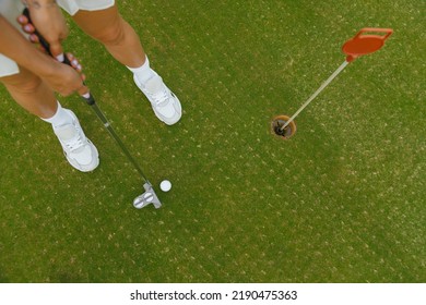 Woman Holding Golf Club Going To Hit Golf Ball Near Hole, Top View. View From Above, Golf Game Play