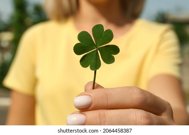 Woman Holding Green Four Leaf Clover Outdoors, Closeup