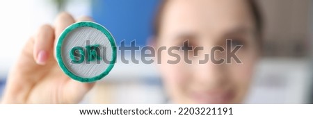 Woman holding green ink stamp OK in her hand closeup