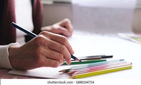 woman holding green pen.Middle-aged  woman preparing paint.