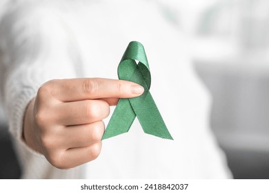 Woman holding green ribbon for cancer awareness month. Healthcare and world cancer day concept - Powered by Shutterstock