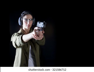 Woman holding a gun with protective gear
