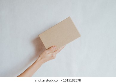 Woman Holding In Hand Small Paper Box. Young Girl With New Package. Postal Service, Delivery. Craft Paper. Gift Box, Present. Box Closeup. Blank Packing, Empty Space. People Communication. Carton Case