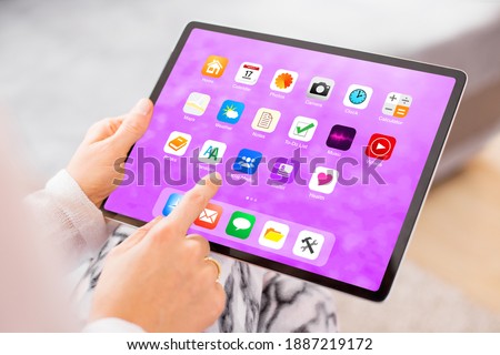 Woman holding in hands and using tablet computer