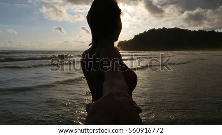 Woman holding hands walking on beautiful sunset
