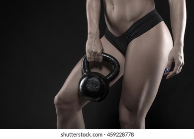 Woman Holding Heavy Kettlebell Closeup On Black Background