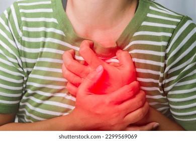 Woman holding her chest with a heart attack. Women have chest pain caused by heart disease, attack, heart leak, coronary artery disease, acute pain can cause a heart attack.