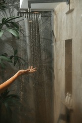 Woman Holding Her Hand Under The Flowing Water In The Shower Cabin