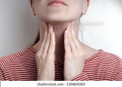 A Woman Is Holding Her Hands On A Sore Throat.