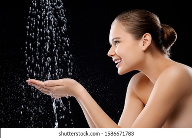 A Woman Holding Her Hands Under A Shower Of Water, Smiling, Toothy Smile