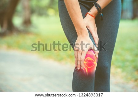 Woman holding her knee with red pain on the skeleton