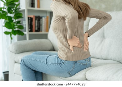 woman holding her lower back while and suffer from unbearable pain health and problems, chronic back pain, backache in office syndrome, scoliosis, herniated disc, muscle inflammation - Powered by Shutterstock