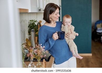 Woman holding her newborn baby and cup with tea - Powered by Shutterstock