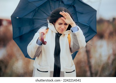 
Woman Holding Her Umbrella Walking into a Windstorm. Unhappy person struggling in a storm fighting strong wind
