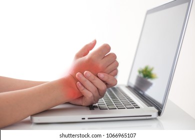 Woman holding her wrist pain from using computer.,Hand pain