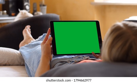 Woman Holding a Horizontal Green Screen Tablet, Lying on the Bed