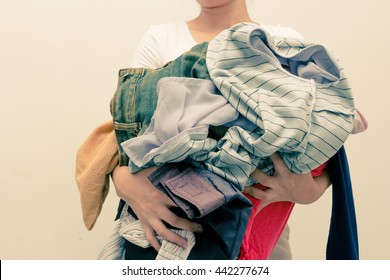 Woman Holding A Huge Pile Of Clothes . Concept Laundry And Clothing
