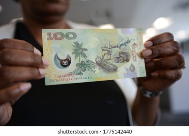 A Woman Holding A Hundred Papua New Guinea Kina Bill.