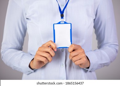 Woman Holding Identification White Blank Plastic Id Card. Young Woman Holding A Mock-up Blank Business Card And Smiling. Woman Wear Blank Vertical ID Badge Mockup, Stand Isolated. 