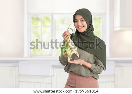 woman holding ketupat on white background