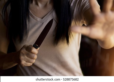  Woman Holding A Knife In Hand While Defending Herself From Attacks.