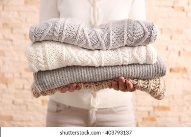 Woman holding knitted clothes, closeup