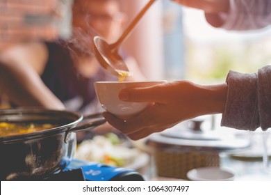 Woman holding ladle in the hand for preparing dinner.