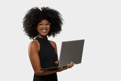 Woman Holding Laptop Computer Typing On Keyboard Looking At Camera, Black Woman