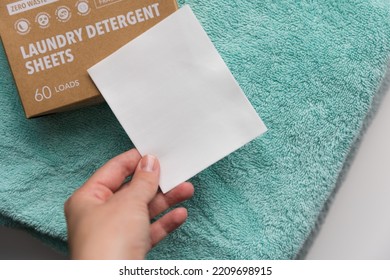 Woman holding a laudry sheet - Shutterstock ID 2209698915