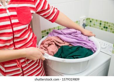 Woman Holding Laundry Basket Full Of Colorful Dirty Towels.