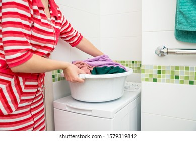 Woman Holding Laundry Basket Full Of Colorful Dirty Towels.