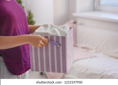 Woman Holding Laundry Basket In Room