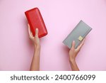 Woman holding leather purses on pink background, closeup