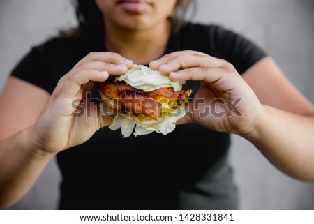 woman holding lettuce burger  , keto burger, woman on keto diet