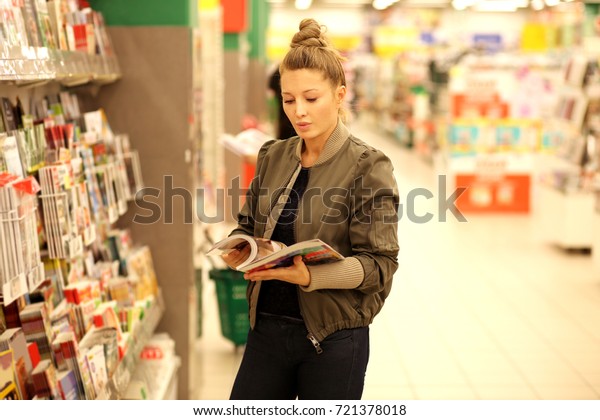 Woman holding\
magazine,buying a book in a\
store