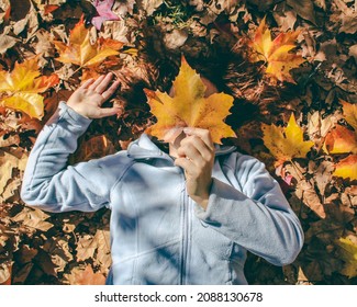 Woman Holding Maple Leaf In Front Of Her Face In Autumn