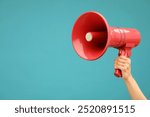 Woman holding megaphone speaker on blue background, closeup. Space for text