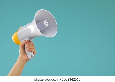 Woman holding megaphone speaker on blue background, closeup. Space for text