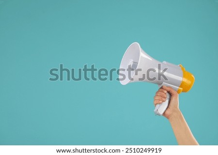 Woman holding megaphone speaker on blue background, closeup. Space for text