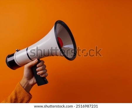 Woman holding megaphone speaker on orange background