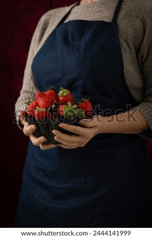 Woman holds strawberries in her hands