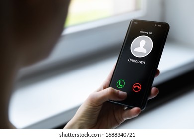 Frau, die ein Mobiltelefon hält und einen Anruf von unbekannten Anrufern entgegennimmt