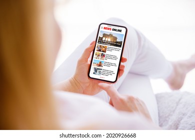 Woman holding mobile phone and reading news online